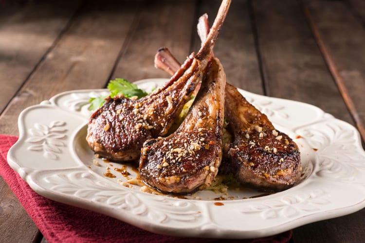 Three lamb chops on a white plate