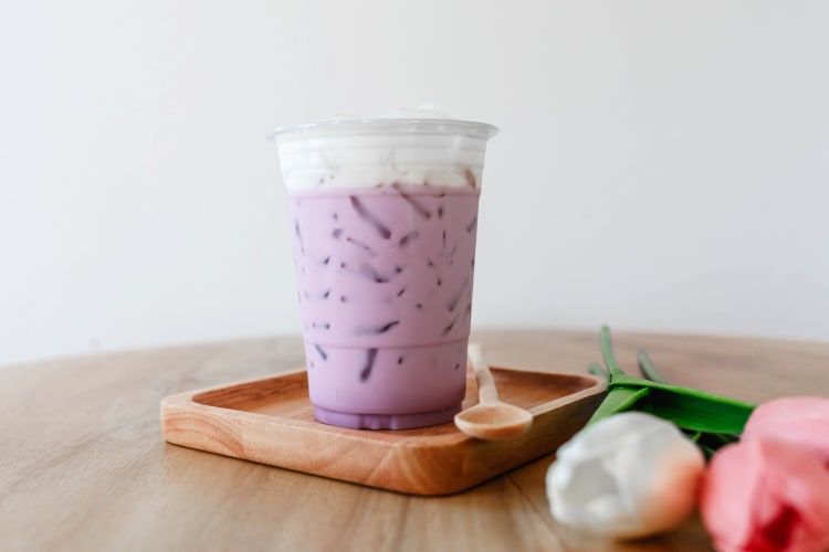 Iced taro tea with milk in a plastic cup