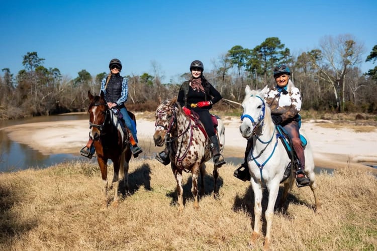 three people riding horses
