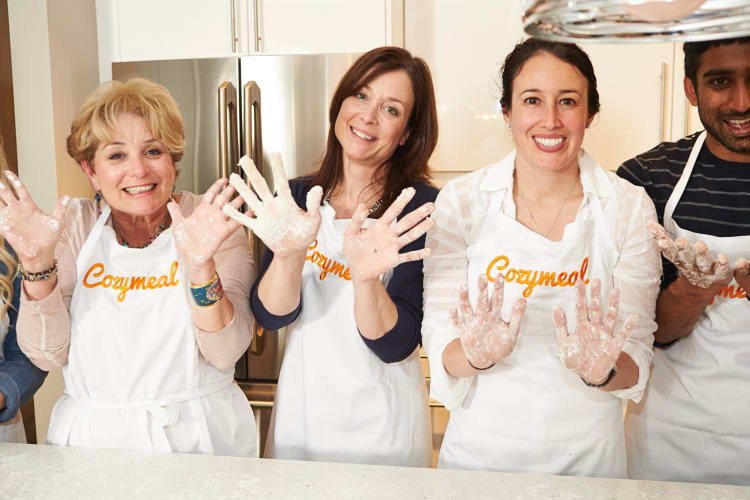 Four people showing their messy hands during a cooking class
