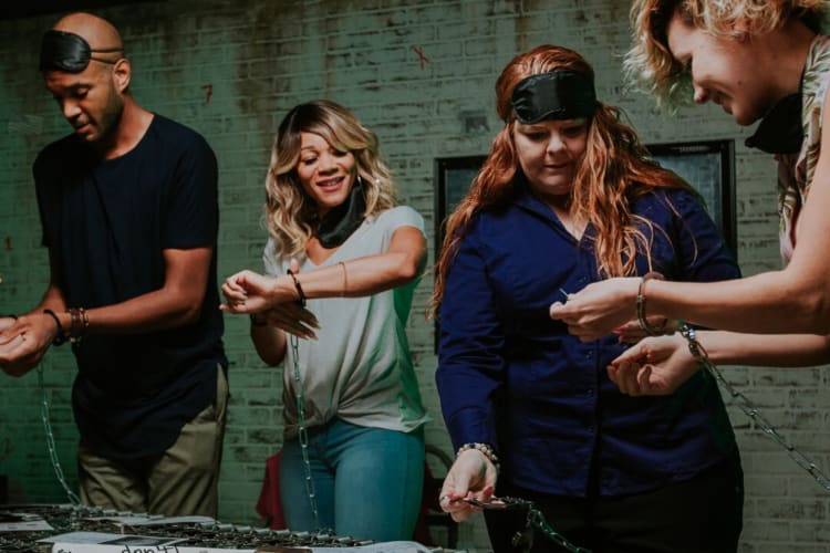 Four people handcuffed at Breakout Games, a fun place for team building activities in Charlotte