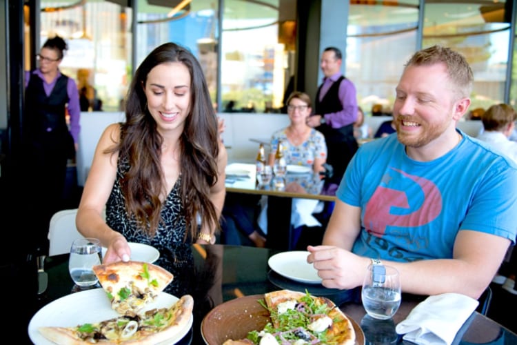 Two people eating pizza on a food tour, which is a great team building activity in Chicago