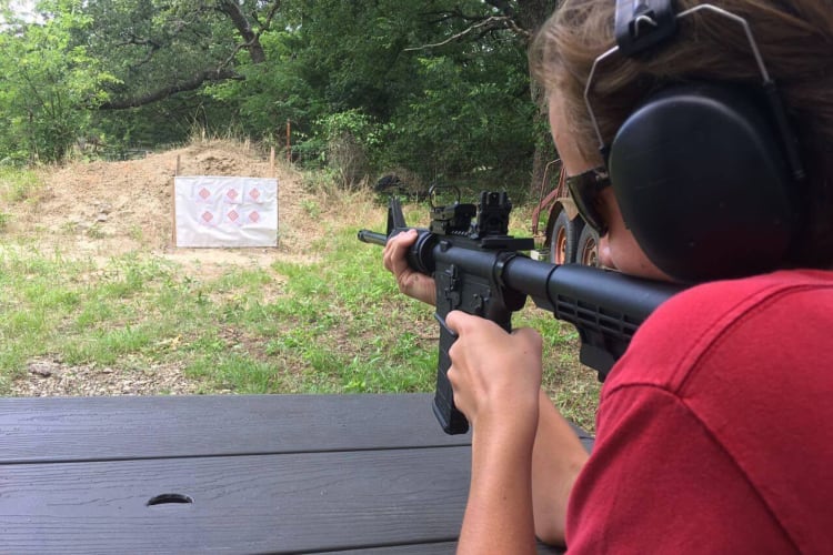 A person shooting at a target, which is a fun team building activity in Dallas