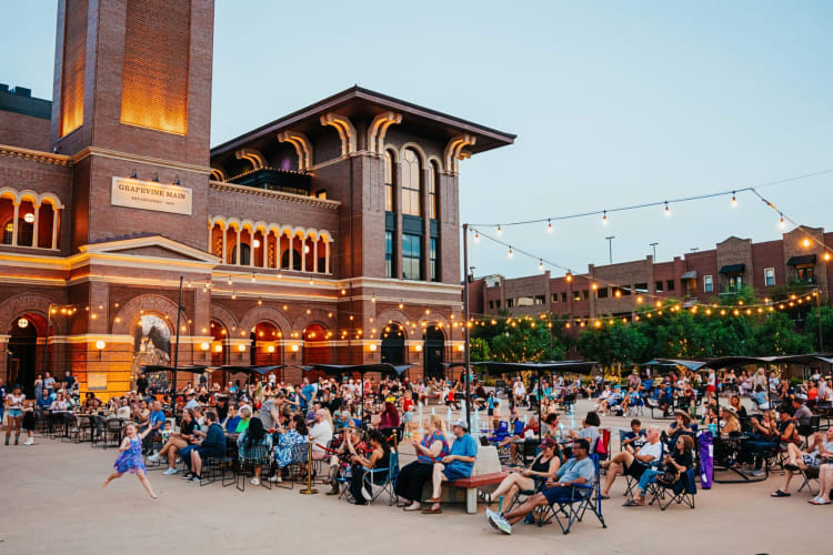 People sitting outside next to a large building in Grapevine, Texas