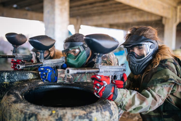 Team of paintball players aiming their guns.