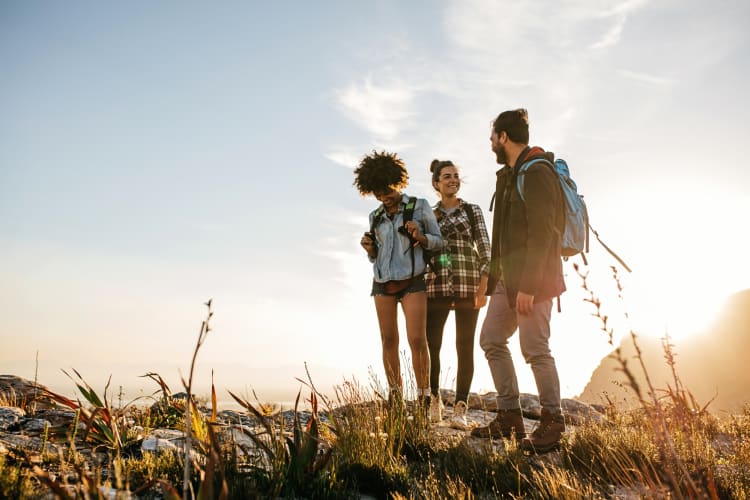 Three people chatting and laughing during a hike — a great idea for a team building activity in San Antonio