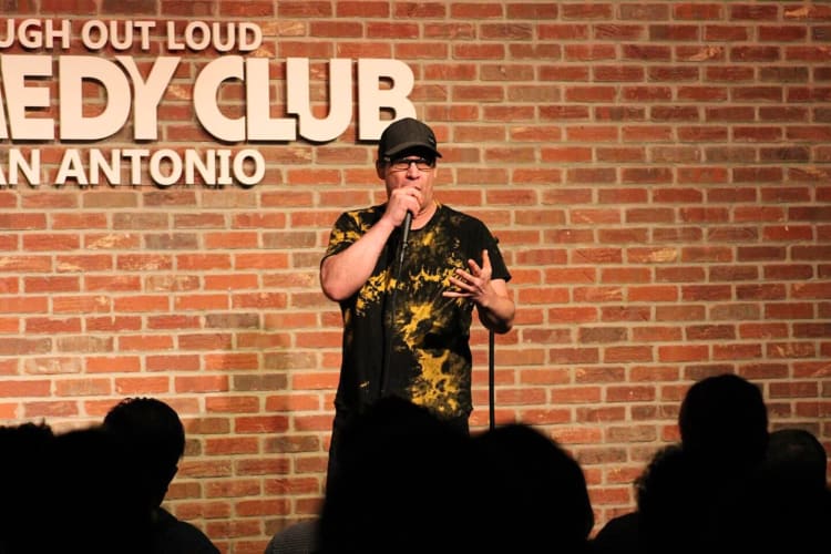 A comedian performing at Laugh Out Loud Comedy Club — a great place to go for a team building activity in San Antonio