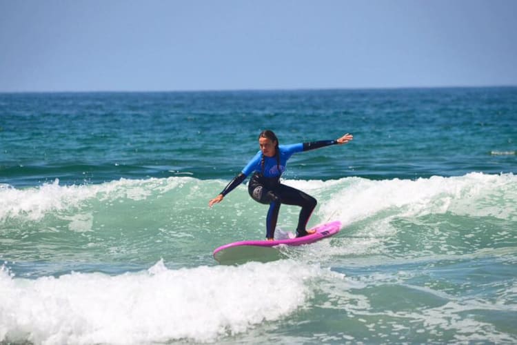 A woman surfing, which makes for a fun team building activity in San Diego