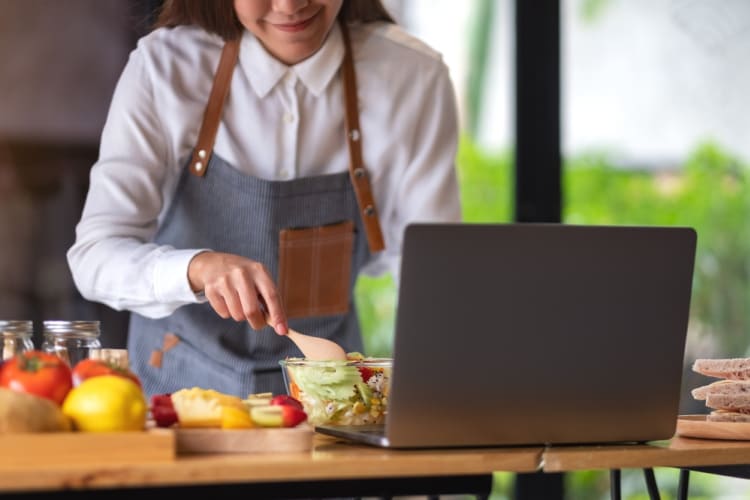 a woman preparing a salad in an online cooking class