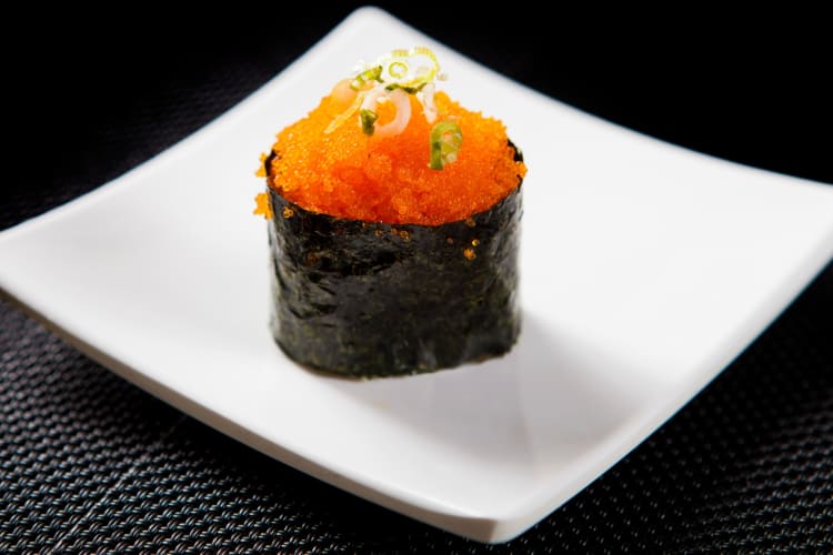 Tobiko and nori-wrapped rice on a ceramic plate