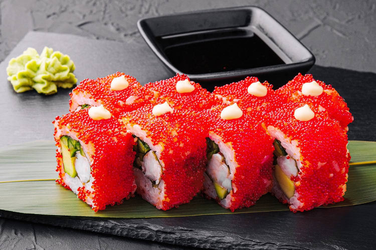 California uramaki with red tobiko served with soy sauce