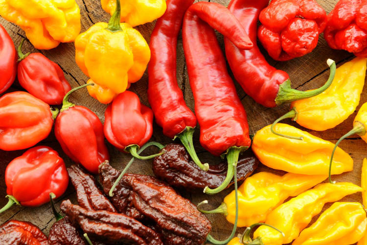 Various hot peppers on a wooden surface.