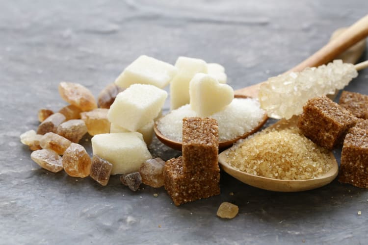 Different types of sugar on some wooden spoons