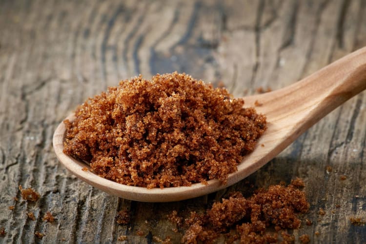 Spoon of muscovado sugar on a wooden table