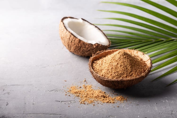 A type of sugar in a coconut bowl with a palm leaf