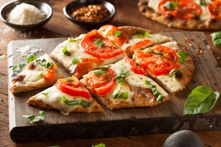 Margarita flatbread served on a wooden board