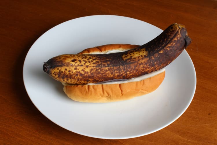 Rotten banana in a bun with mayonnaise