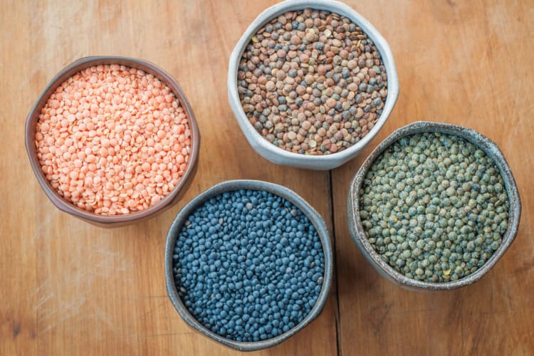 Four bowls of different varieties of dried lentils 