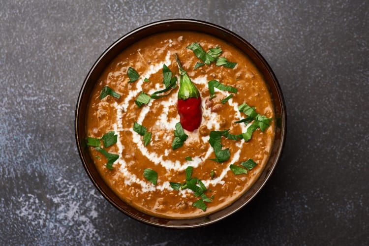 A bowl of Dal Makhani on a dark table