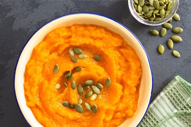 A bowl of pumpkin mash topped with pepitas