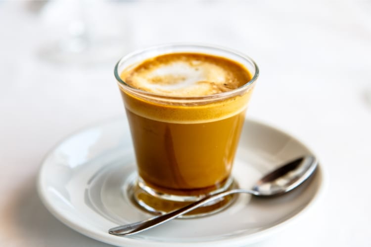 A cortado coffee in a glass cup