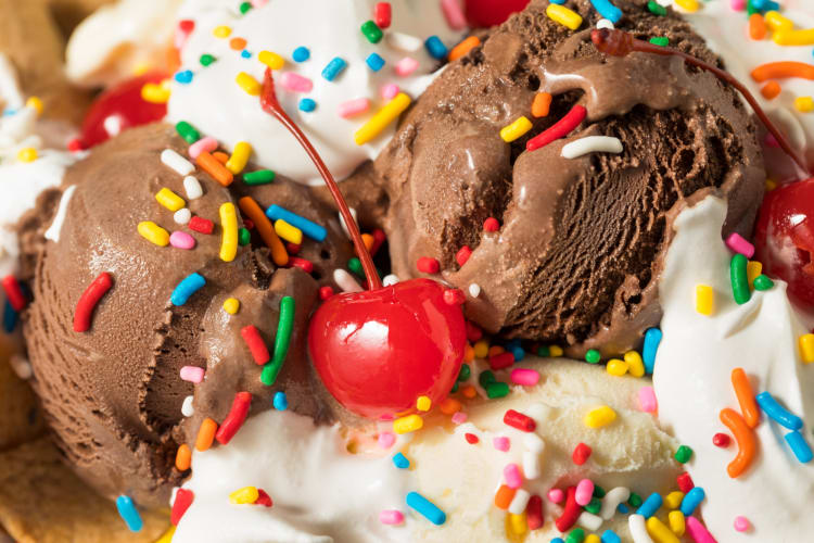 Chocolate and vainilla ice cream served with cherry and sprinkles