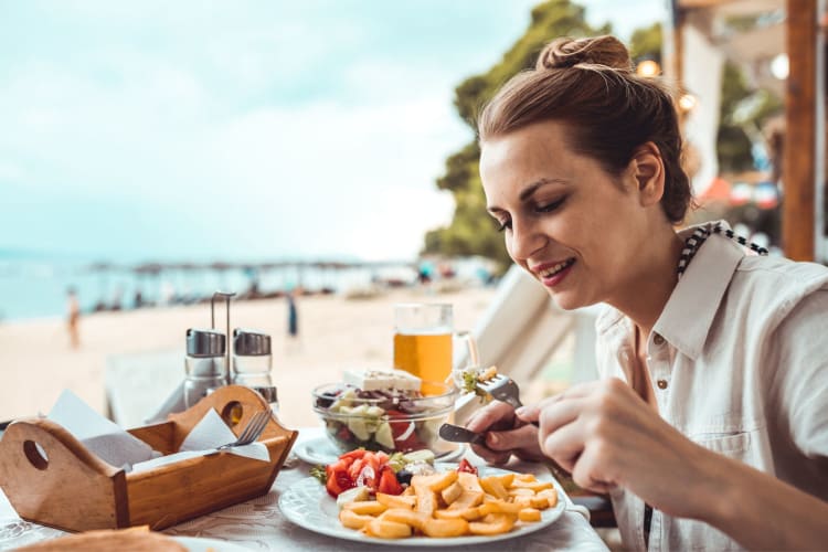 Woman eating breakfast in St. Petersburg on the beach