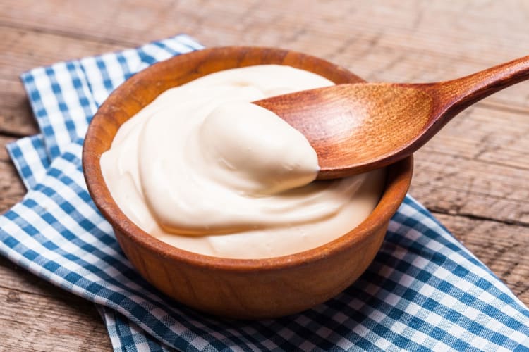 bowl of sour cream with wooden spoon