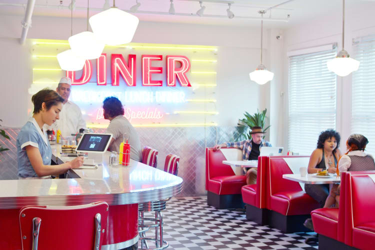 Waitress and customers in a 1950s styled diner