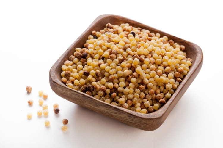 Fregola on a wooden bowl