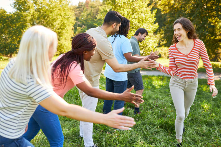 team leader giving high five to line-up of co-workers outside