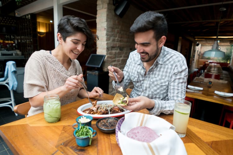 A couple eating nachos at an outdoor table