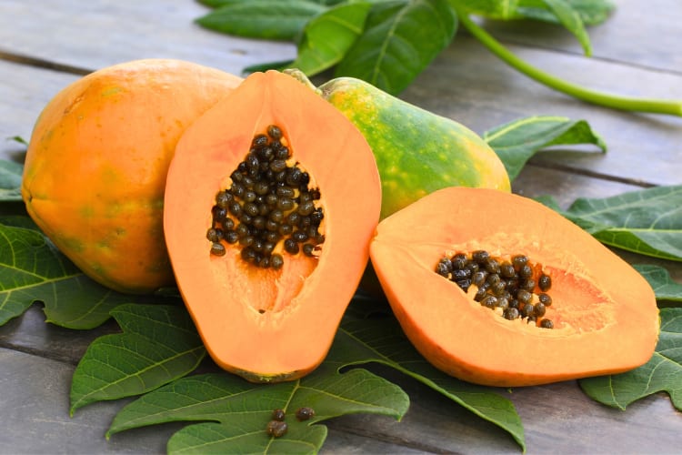 Whole and halved papayas