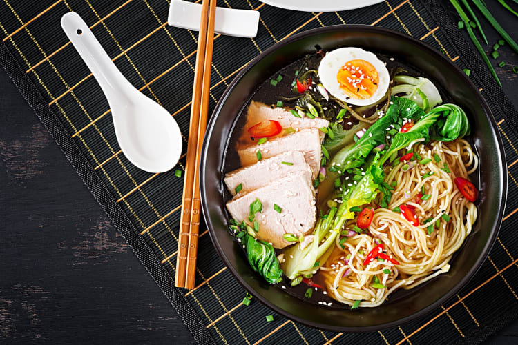 A bowl of miso ramen with meat, greens and noodles