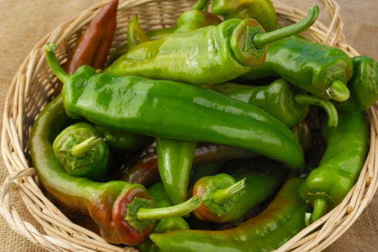 Green Anaheim peppers shown in a basket.