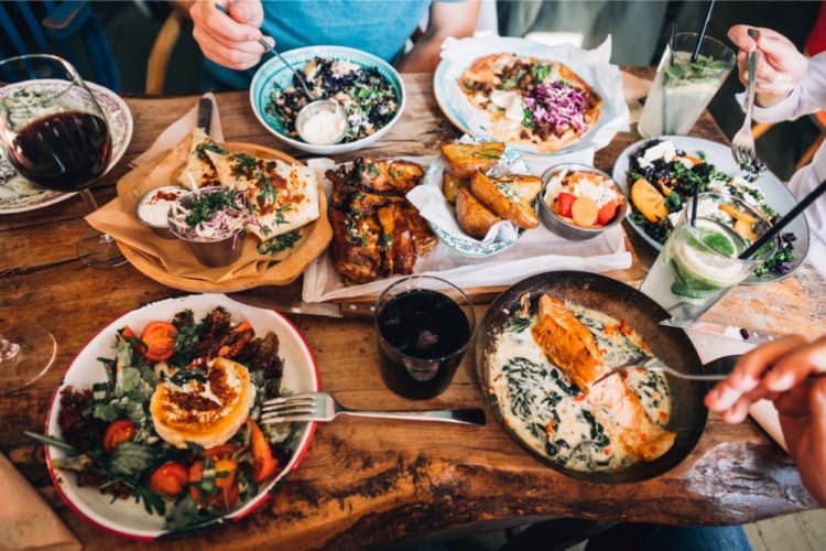 A group of people share healthy dishes.