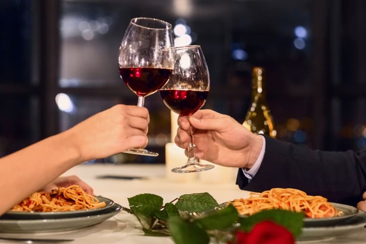 Two people making a toast in a romantic restaurant