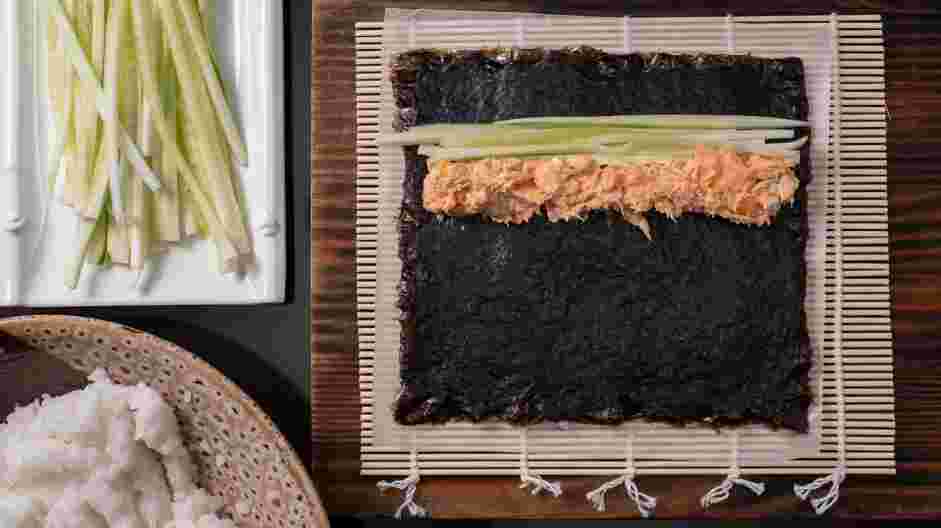 Salmon Skin Roll Recipe: Next, lay cucumber strips near one edge of the nori.