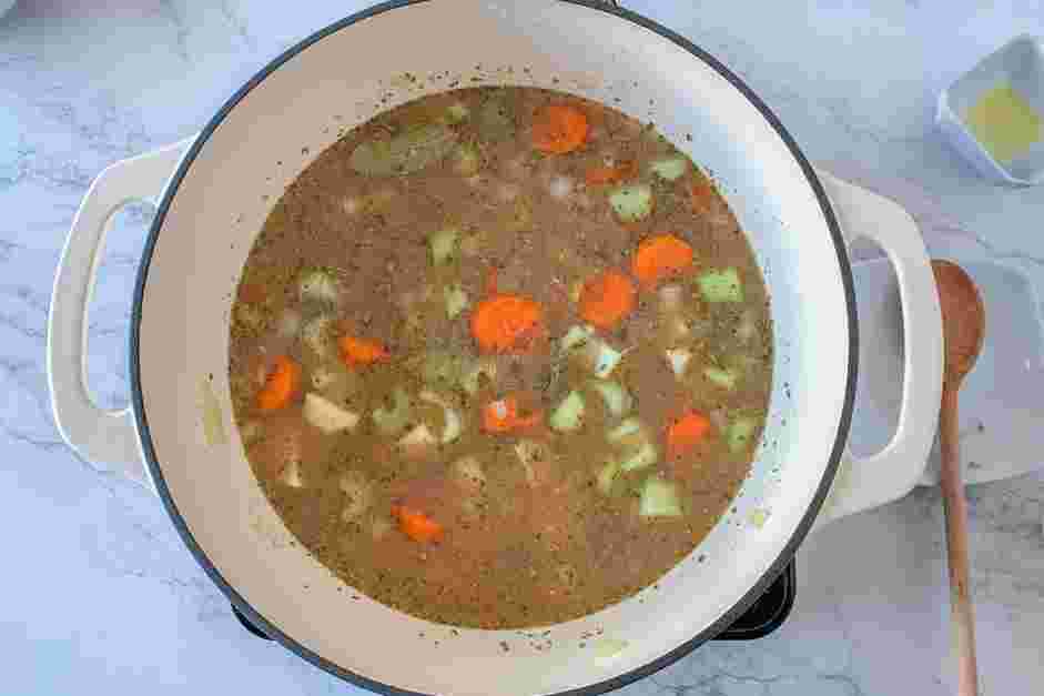 Vegan Potato Soup Recipe: Pour in the stock and add the garlic, oregano and bay leaves.