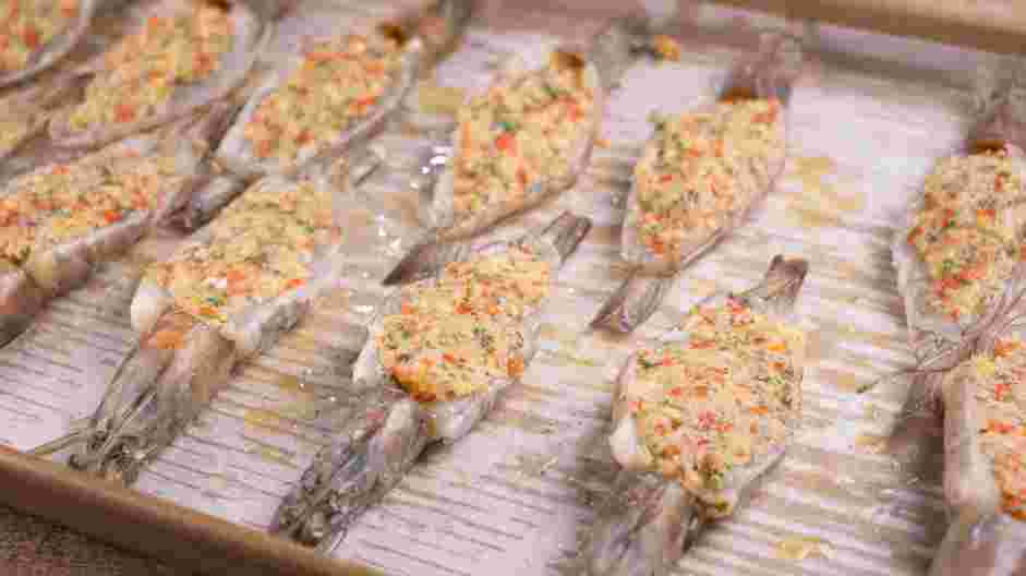 Baked Stuffed Shrimp Recipe: Spoon a small mound of breadcrumb mix into the body of the butterflied shrimp, creating a dome-like shape.