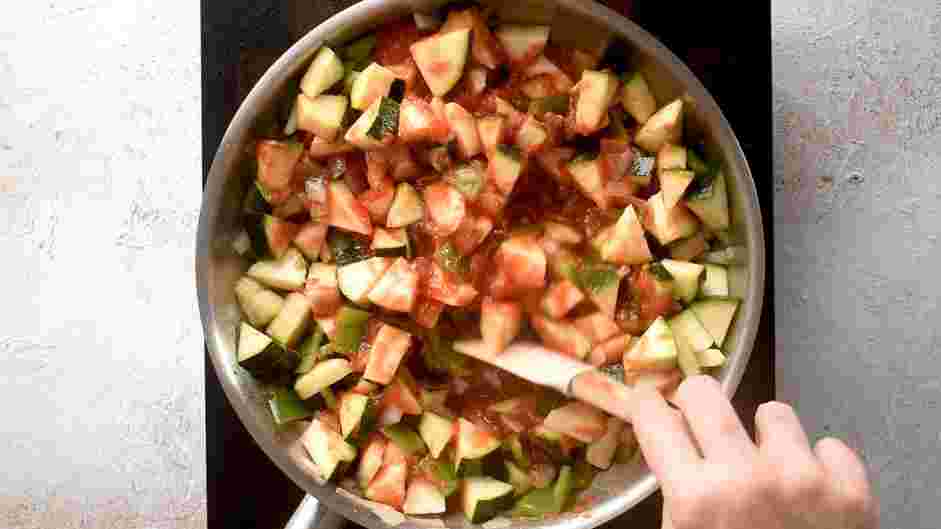Pisto Manchego Recipe: Add the zucchini and tomato to the pan and stir together.