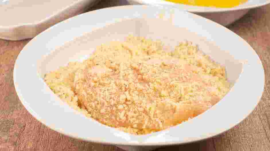 Keto Chicken Parmesan Recipe: Dredge chicken in the cheese and almond flour mixture, pressing the chicken against the mixture so it sticks.