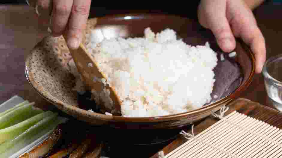 Easy Caterpillar Roll Recipe: In a medium bowl, fluff cooked rice with a fork while stirring in the vinegar mixture.