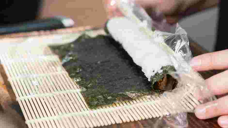 Easy Caterpillar Roll Recipe: Lift one edge of the rolling mat and tightly roll up to the other end.