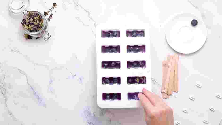 Lemon Blueberry Boba Popsicles Recipe: Once they are nearly full, add three blueberries to each popsicle.