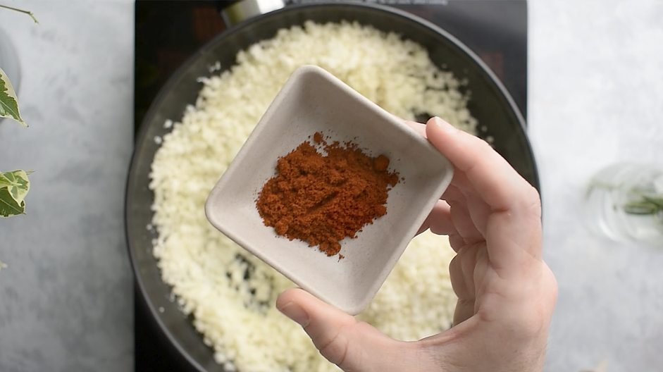 Spanish Cauliflower Rice Recipe: Add the cauliflower rice, Spanish paprika, garlic powder, salt and pepper.