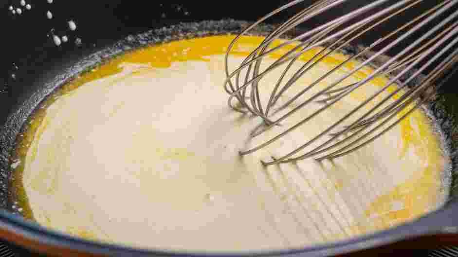 Keto Alfredo Sauce Recipe: Slowly whisk in the heavy cream, creating an emulsion.