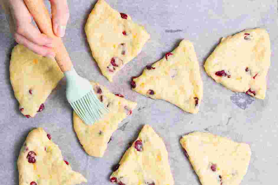 Cranberry Orange Scones Recipe: Brush the wedges with the reserved egg mixture and sprinkle with coarse sugar.