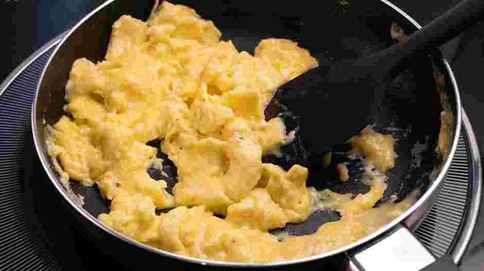 Fluffy Scrambled Eggs Recipe: Using a silicone spatula, push the edges of the eggs to the center, letting the uncooked eggs flow to the edges.