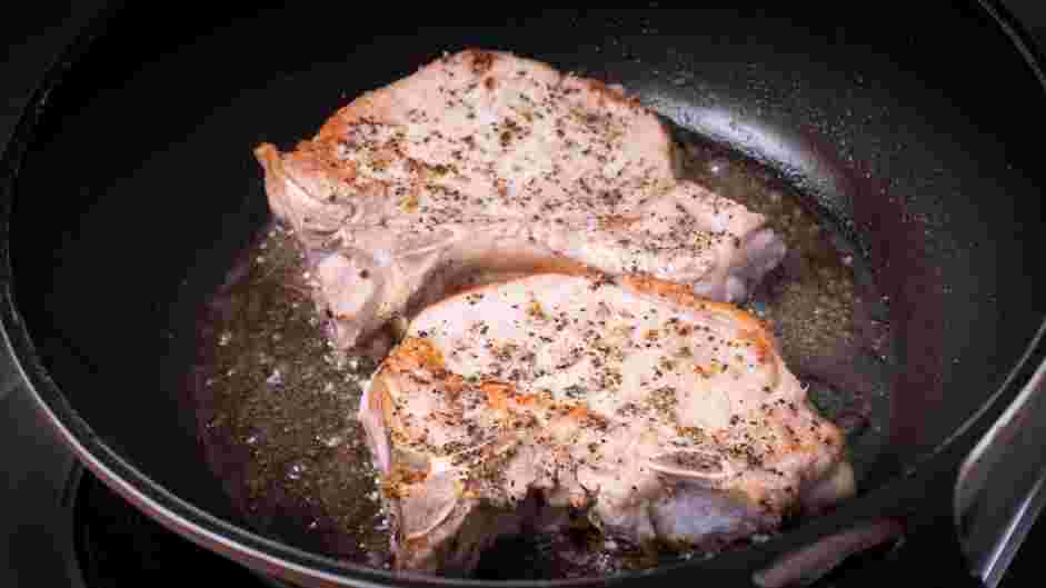 Skillet Pork Chops Recipe: Sear the pork chops until golden brown, about 1 minute on each side, including the fat cap.